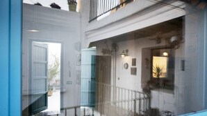 Un edificio moderno con puerta de cristal que da a un balcón, una escalera y una barandilla.