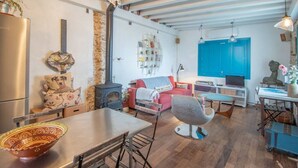 Una sala de estar acogedora con chimenea, una mesa de comedor y un sofá.