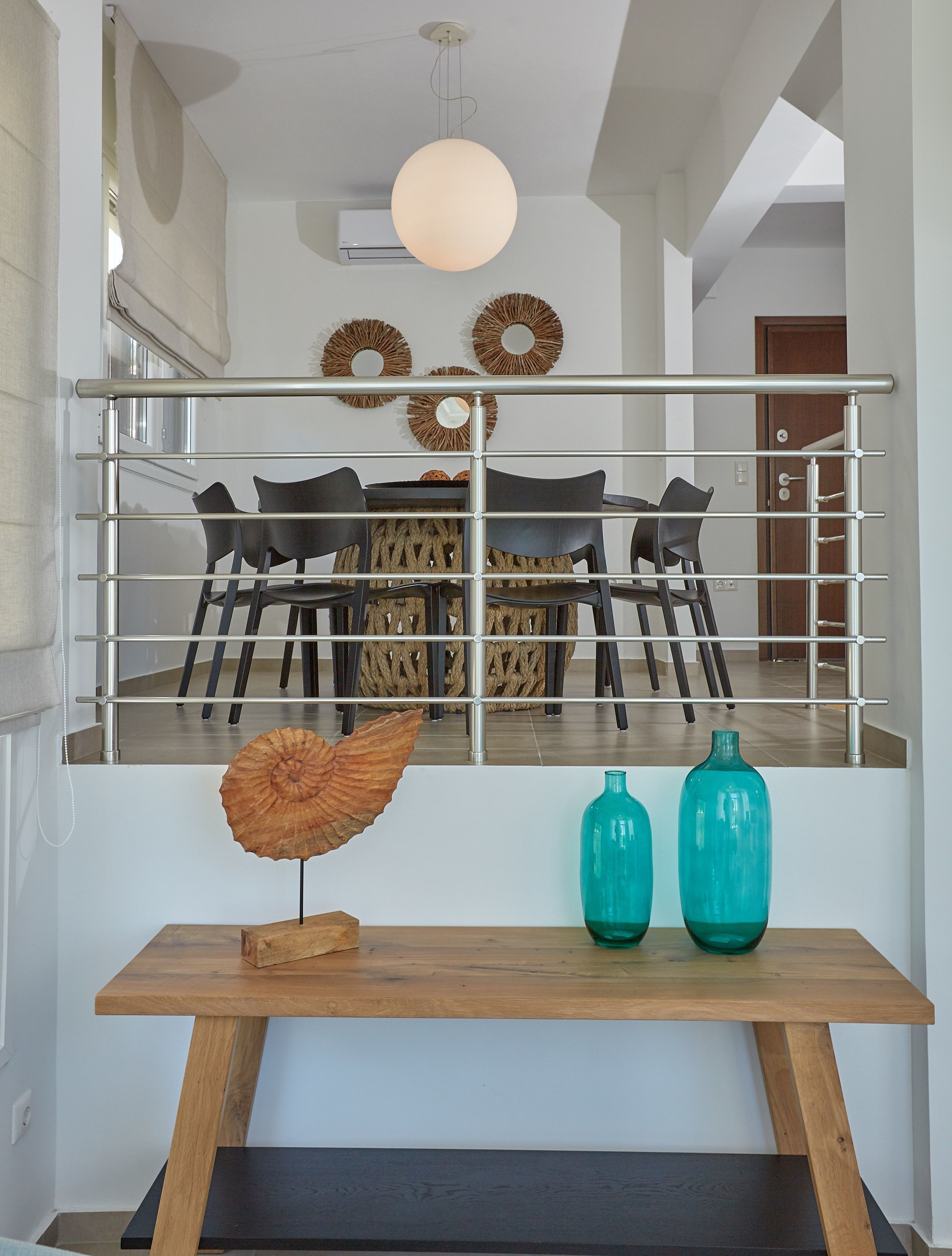 A modern interior with a dining area, a staircase, and decorative wall art.