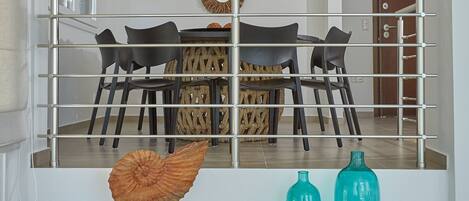 A modern interior with a dining area, a staircase, and decorative wall art.