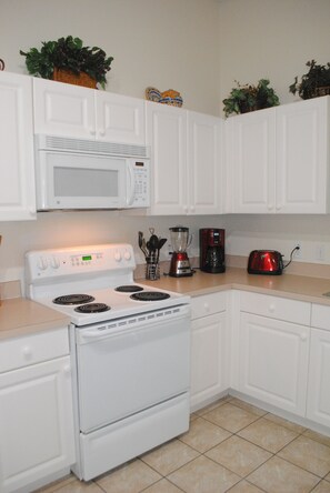 Kitchen features a stove, microwave, coffee maker, and toaster, with ample space for cooking and entertaining.