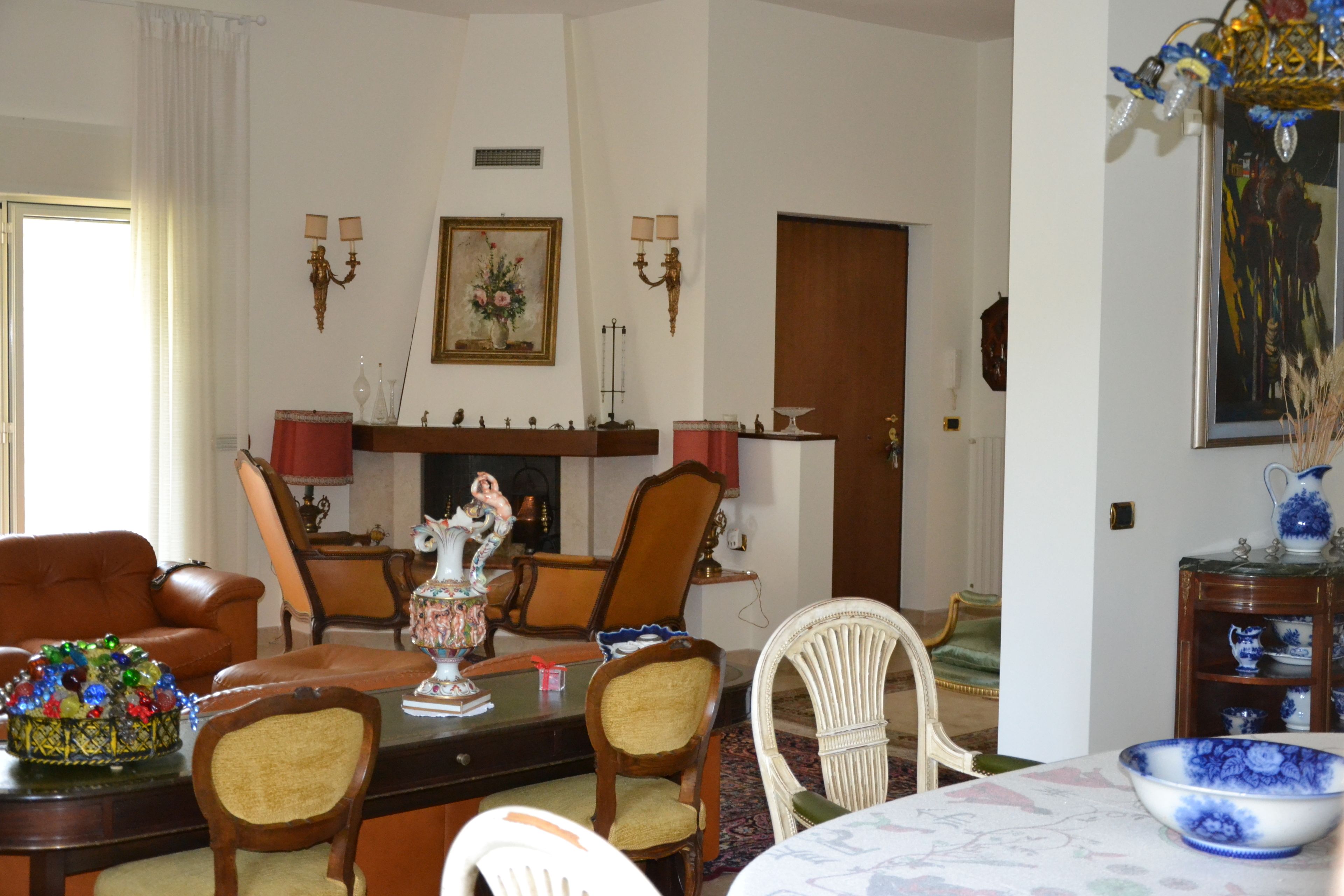Una sala de estar tradicional con chimenea, muebles de cuero y objetos decorativos.