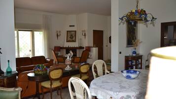 A dining area with a table set for four, surrounded by chairs.