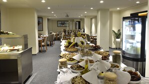 A buffet setup with various food items and a refrigerator.