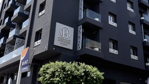 A modern hotel building with multiple balconies and a sign for 'BIAT Change'.