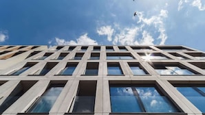 A modern building with a grid of windows and a clear sky.