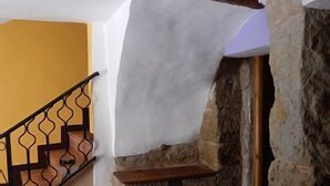 A staircase with a stone wall and a yellow wall in the background. - Rural house for 4 people (Ayerbe)