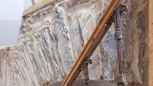 A staircase with ornate metal railings and a stone wall. - Charming Old Farmhouse, Beautifully Restored - ideal base to explore SW Ireland (Coachford)