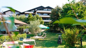 A hotel courtyard with outdoor seating, a pool, and a building with multiple balconies. - Bio-Hotel & Residence Kaufmann (Ora)
