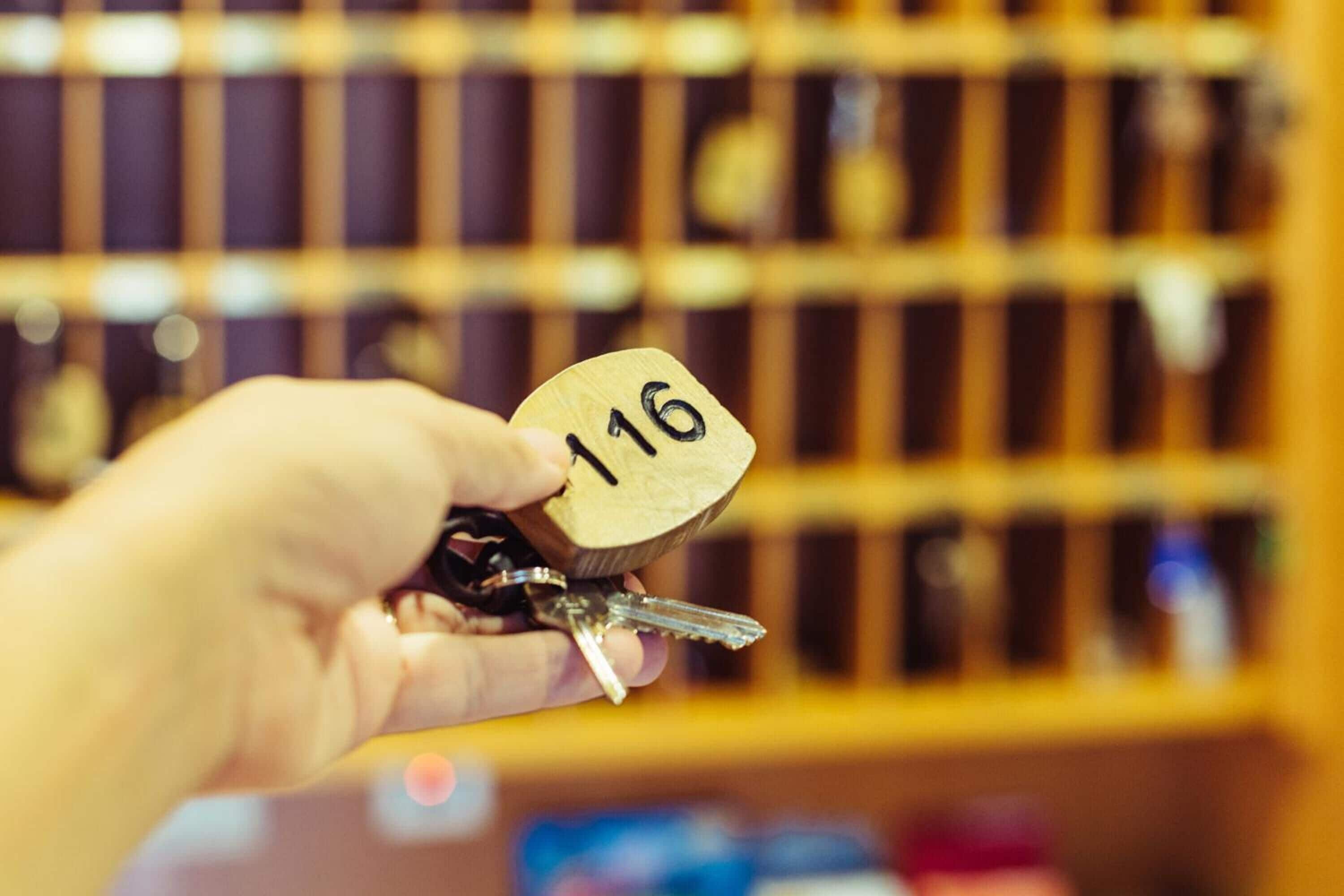 Una mano sosteniendo una llave con el número 116.