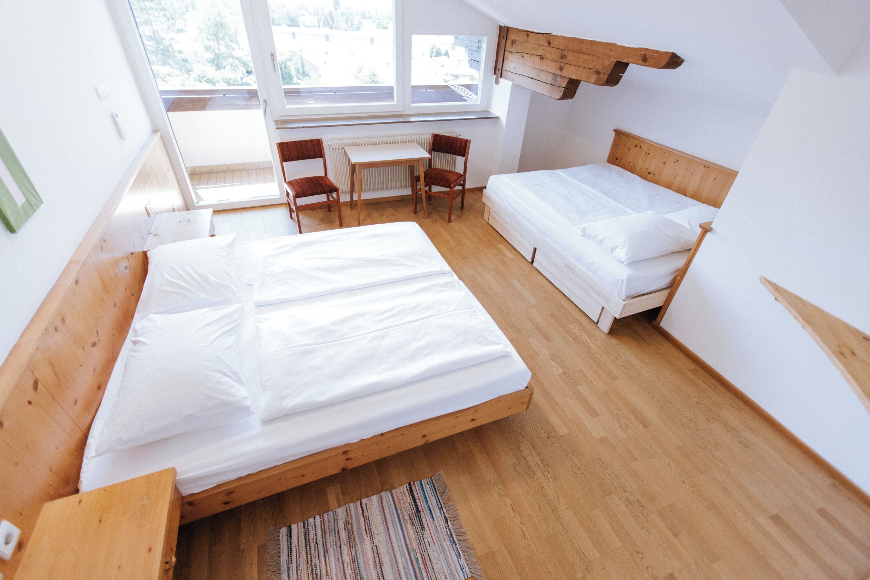 A room with two beds, a desk, and a chair.