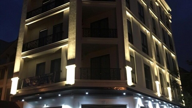 A multi-story hotel with a corner entrance, balconies, and a well-lit facade. - Pure Stay (Hai Phong)