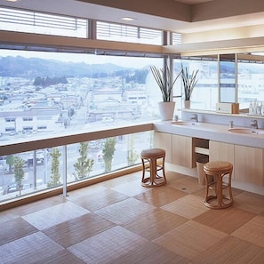 A modern bathroom with a large window, two stools, and a mirror. - Yokote Onsen Hotel Plaza Geihin (Yokote)