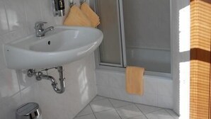 Ein Badezimmer mit Waschbecken, Spiegel und Dusche.
