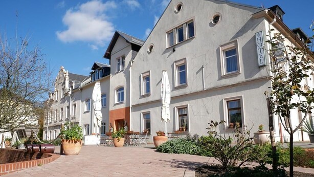 Ein Hotel mit Innenhof, der mit Blumentöpfen und Sitzgelegenheiten im Freien ausgestattet ist.