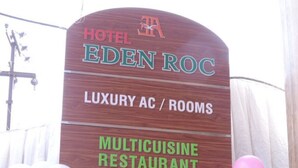 A sign for Hotel Eden Roc highlighting its luxury accommodations, multicuisine restaurant, food take-away counter, bar, and tours & travels services. - Hotel Eden Roc (Bhubaneshwar)