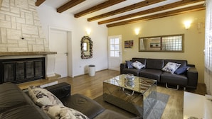Una sala de estar con chimenea, un juego de sofá, una mesa de centro y un espejo en la pared.