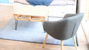A modern bedroom with a bed, a chair, a hanging light fixture, and decorative wall art. - House for 4 travelers, with private courtyard - between the city center and the port (Saint-Brieuc)