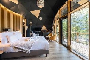 Une chambre d’hôtel moderne dotée d’un grand lit, d’un bureau et offrant une vue sur l’extérieur.