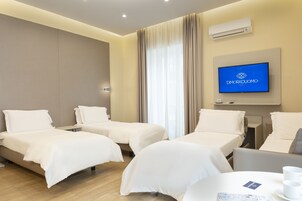 Una camera d'albergo con due letti, una televisione e un tavolo con tazze e un menu.