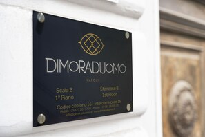 A sign with the name 'DIMORADUOMO' and location details for 'Scala B 1° Piano' and 'Staircase B 1st Floor'. - Dimora Duomo (Naples)