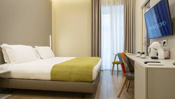 A hotel room with a bed, desk, chair, and a television displaying 'Dioradduomo'.