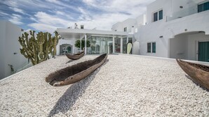 A modern building with white walls and a gravel courtyard. - Guinate Club Apartamentos (Tías)