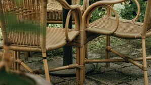 A wicker table and chairs set outdoors with lush greenery in the background. - Hotel Beijers (Utrecht)