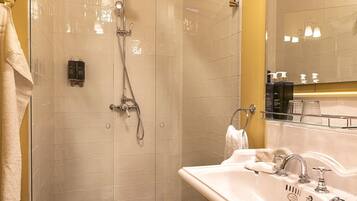 A bathroom with a shower, a sink, and a mirror.