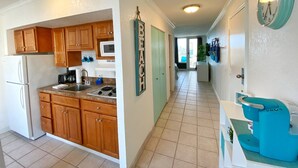 A modern kitchen with wooden cabinets, a refrigerator, and a coffee machine.