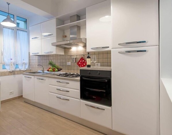 Stort kylskåp, ugn, spishäll och grytor/köksredskap