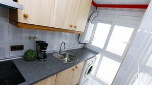 A modern kitchen with a built-in dishwasher, a coffee maker, and a sink. - SOBREMAR Apartment - STUNNING Views (Salou)