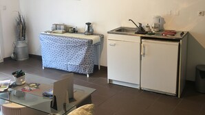 A compact living space with a kitchenette, a dining area, and a sofa. - Le Palmyre Soleil de l'Amazonie (La Douze)