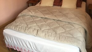 A bedroom with a bed, a nightstand, and a wall socket. - Le Palmyre Soleil de l'Amazonie (La Douze)