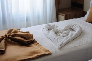 A neatly made bed with a folded towel and a brown blanket. - Grand Hekimoglu Hotel (Izmir)