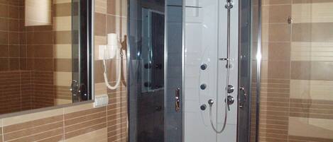 A modern bathroom with a glass-enclosed shower, a sink, and a mirror.