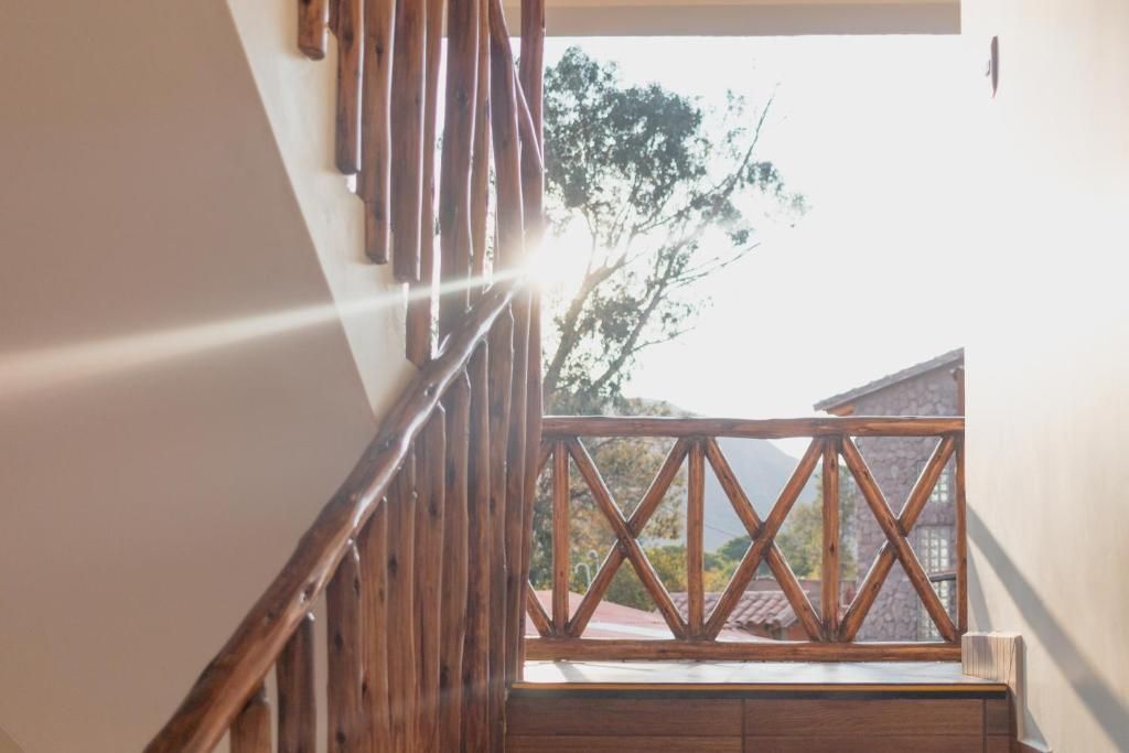 Una escalera de madera que lleva a un balcón con vista a una montaña y árboles.