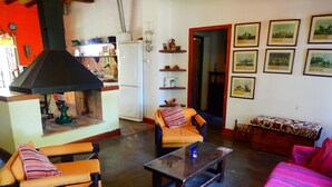 A living room with a fireplace, two armchairs, a sofa, and a coffee table. - Rincón de la Finca (Luján de Cuyo)