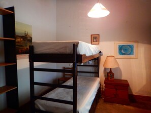 A bunk bed room with a lamp and a dresser. - Rincón de la Finca (Luján de Cuyo)