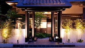 A traditional Japanese-style building with a tiled roof, wooden columns, and a small tower with illuminated signage. - Hanare Matsushimakaku (Aizuwakamatsu)