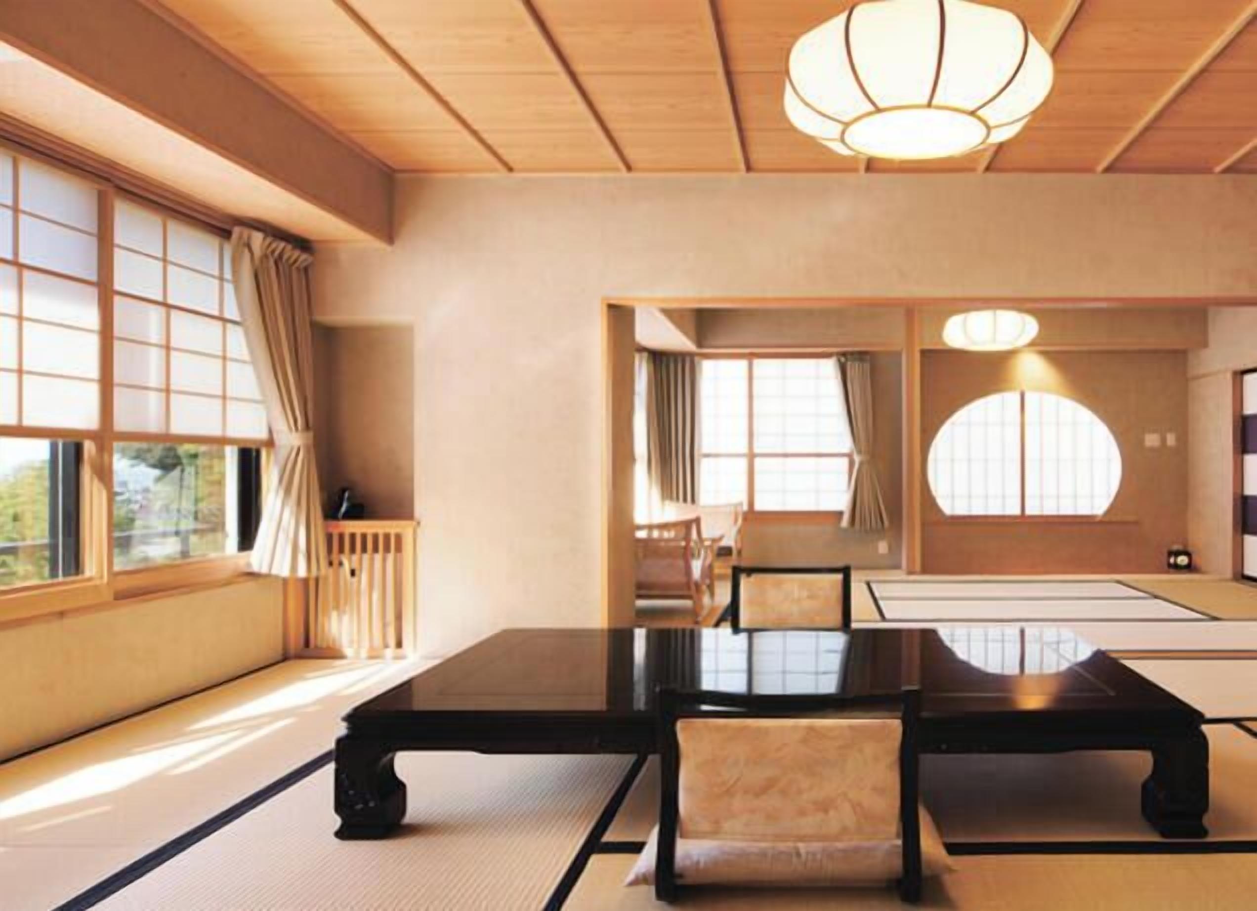 A traditional Japanese room with tatami flooring, a low table, and chairs.