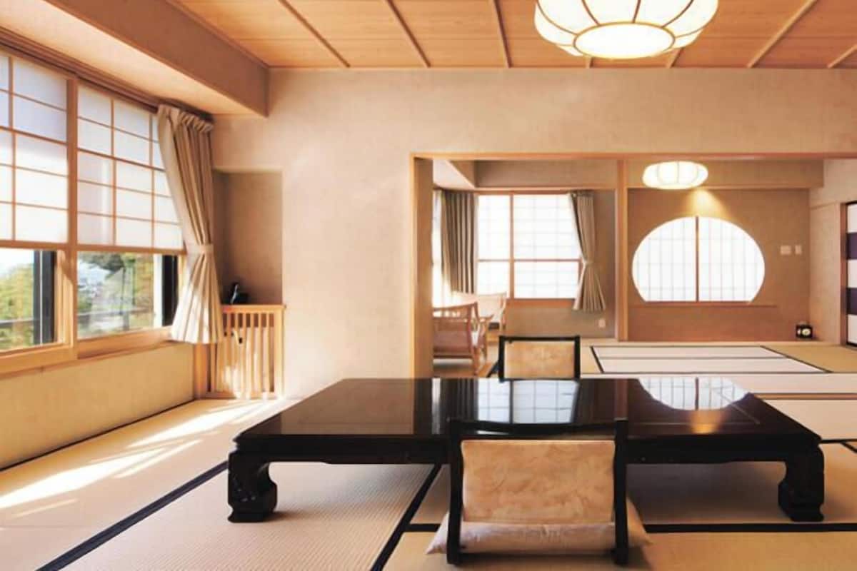 A traditional Japanese room with tatami flooring, a low table, and chairs.