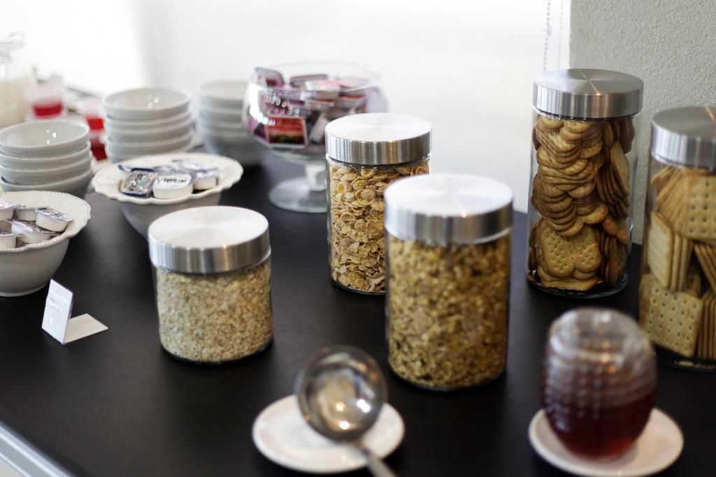 A buffet setup with various food items in jars and bowls.
