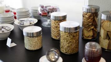 A buffet setup with various food items in jars and bowls.