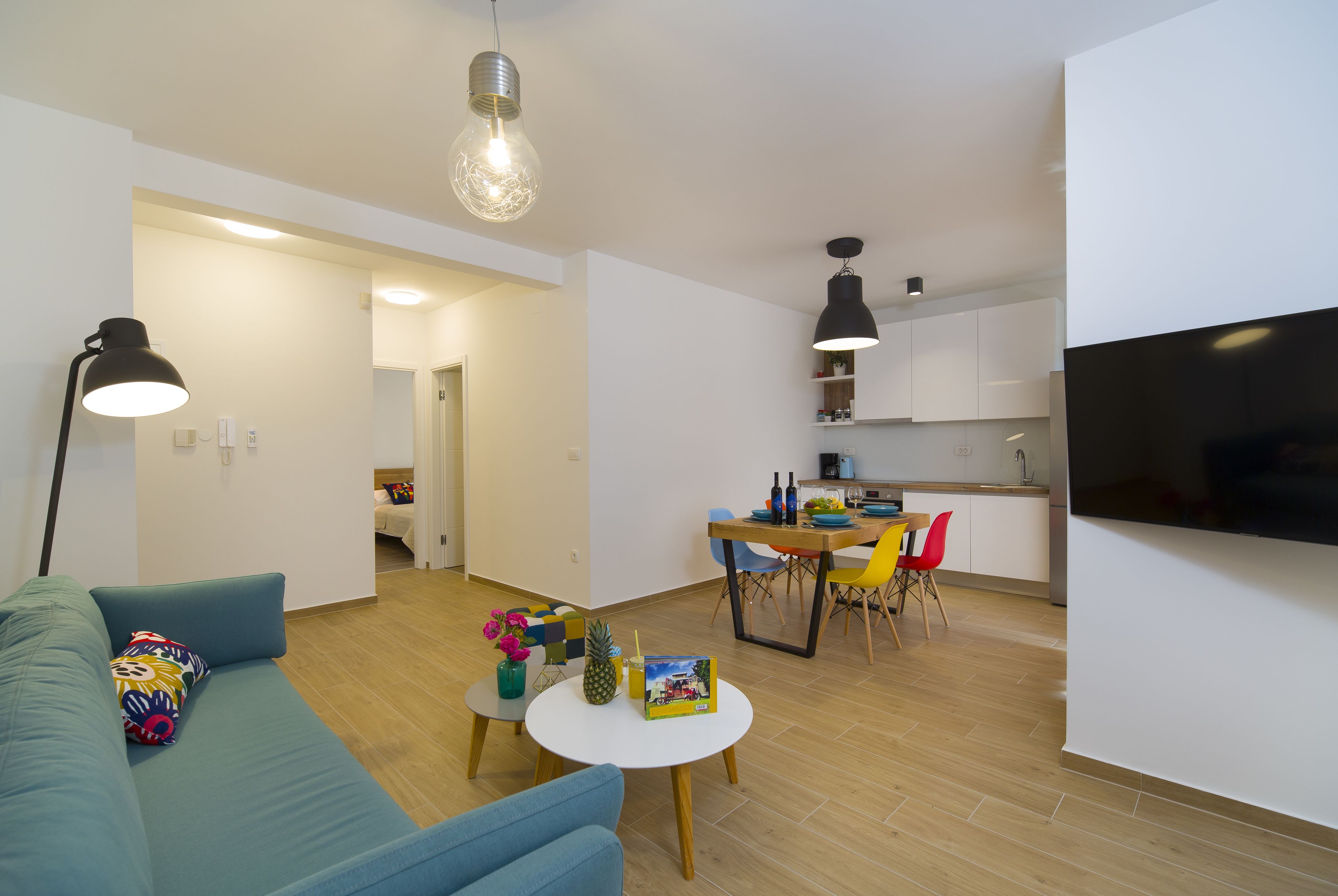 Ein modernes Wohnzimmer mit einer Couch, einem Couchtisch und einem Essbereich mit Stühlen und Tisch.