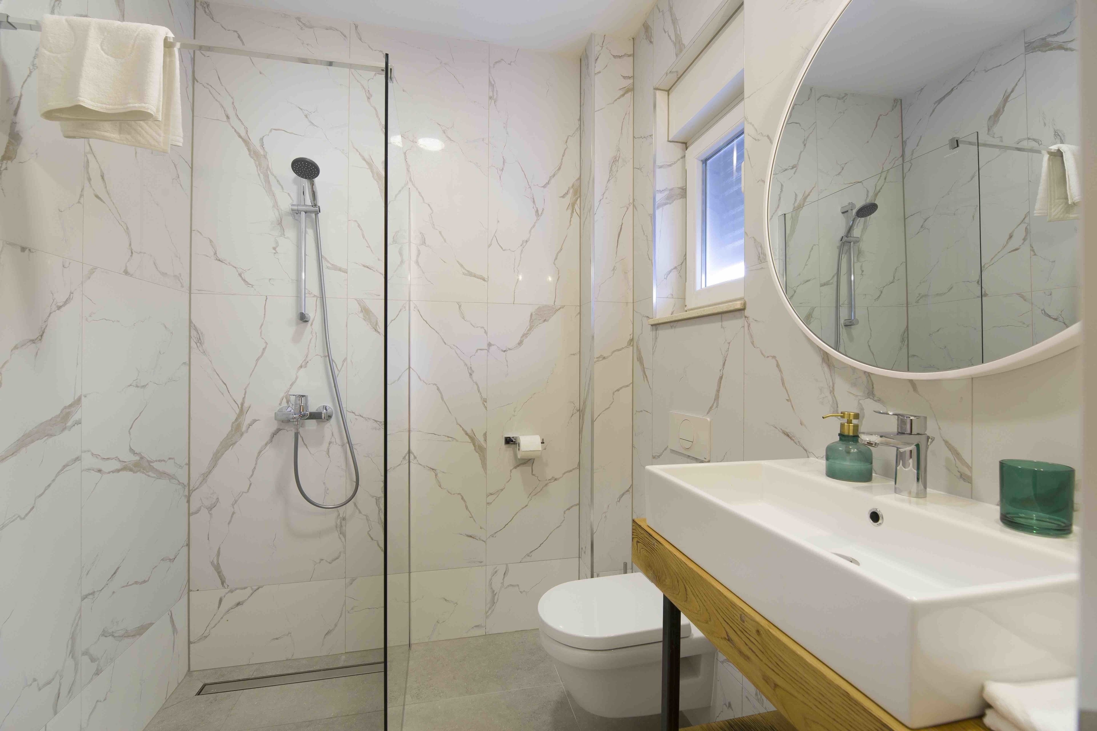 A bathroom with a shower, toilet, and sink.