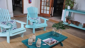 Een gezellige kamer met twee turquoise fauteuils, een klein tafeltje met een tijdschrift en decoratieve lantaarns.