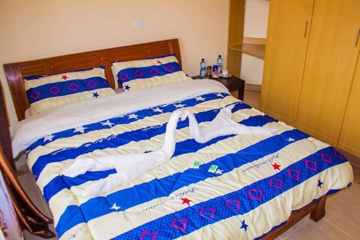 A bed with a blue and white striped bedspread, two pillows, and a wooden headboard.