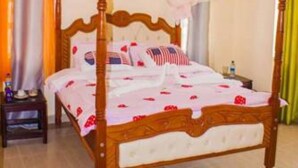 A four-poster bed with a canopy, a bedside table, and a nightstand. - JKIA Tours and Homes (Syokimau)
