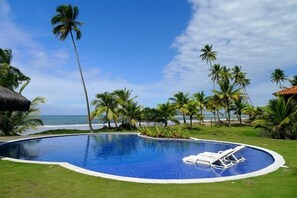 Una piscina al aire libre, sillones reclinables de piscina